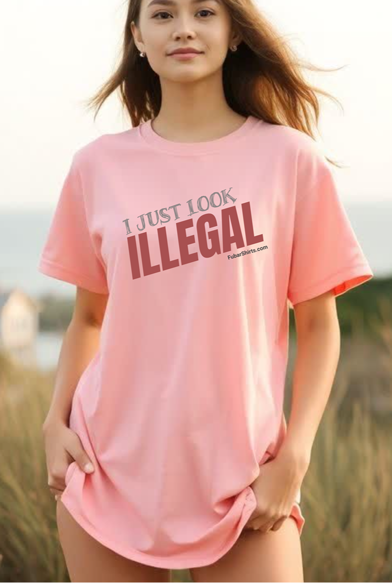 Woman wearing a pink t-shirt with 'I Just Look Illegal' text outdoors.